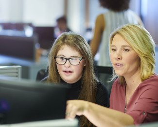 Woman helping learner at computer